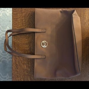 A large tote purse Michael Kors in a camel brown color.